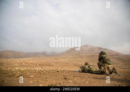 Ungarische Soldaten demonstrieren, wie man ein PKM-Maschinengewehr während der militärischen Ausbildung in Erbil, Irak, abfeuert. Stockfoto