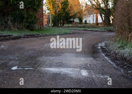 Frost und Eis auf der Straße und Straßenseite im ländlichen Dorf Clyst St George in East Devon während der Rush Hour am frühen Morgen Stockfoto