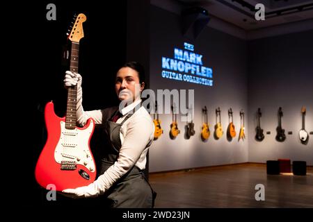 Ein Christie's Kunstführer hält Mark Knopflers Red Schecter Telecaster Gitarre, die Teil der Mark Knopfler Guitar Collection ist, in der Christie's in London zu sehen, bevor sie auf einer Auktion angeboten wird. Bilddatum: Donnerstag, 18. Januar 2024. Stockfoto