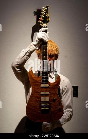 Ein Christie's Kunstführer hält Mark Knopflers 1988 Pensa-Suhr MK-1 Gitarre, die Teil der Mark Knopfler Guitar Collection ist, die im Christie's in London ausgestellt ist, bevor sie auf einer Auktion angeboten wird. Bilddatum: Donnerstag, 18. Januar 2024. Stockfoto