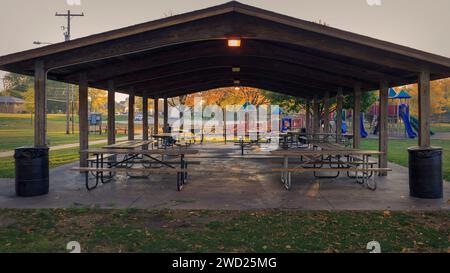 Picknicktische in einem Pavillon sind bereit für die Tagesversammlungen an diesem Sommermorgen Stockfoto