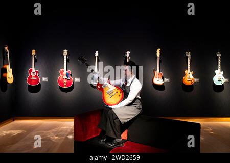 A Christie's Art Handler hält Mark Knopflers 1983 Les Paul Standard '59 Neuauflage Gitarre, die Teil der Mark Knopfler Guitar Collection ist, im Christie's in London ausgestellt, bevor sie auf einer Auktion angeboten wird. Bilddatum: Donnerstag, 18. Januar 2024. Stockfoto