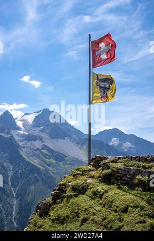 Schweizer Flagge eine Flagge des Kantons URI winkt im Wind auf einer Berghütte in der Schweiz Stockfoto