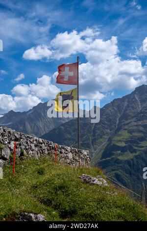 Schweizer Flagge eine Flagge des Kantons URI winkt im Wind auf einer Berghütte in der Schweiz Stockfoto