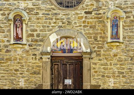 Das Tympanon des Portals der Fassade ist mit Mosaiken von St. verziert Martin, der Bischof, Jeanne von Arc und St. Therese von Lisieux. Villefontaine Stockfoto