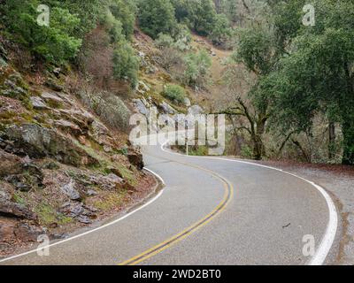 Ein malerischer Blick auf eine Asphaltstraße an einem grünen Berghang Stockfoto