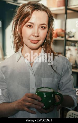 Entspannte Frau mit einer Tasse Tee im Sonnenlicht Stockfoto