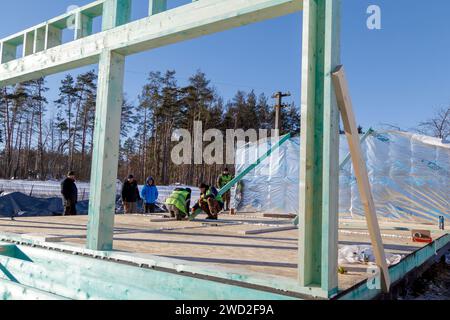 YAHIDNE, UKRAINE - 17. JANUAR 2024 - in Yahidne, Region Tschernihiw, Nord-Ukraine, werden die Arbeiten zum Wiederaufbau eines der von russischen Invasoren zerstörten Häuser durchgeführt, die aus dem Staatshaushalt der Republik Lettland finanziert wurden. Stockfoto