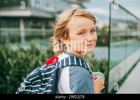 Nahaufnahme Porträt eines jungen süßen 6-jährigen Jungen im Rucksack, zurück zur Schule. Ehrlicher kleiner Schuljunge, Filterbild im Filmlook Stockfoto