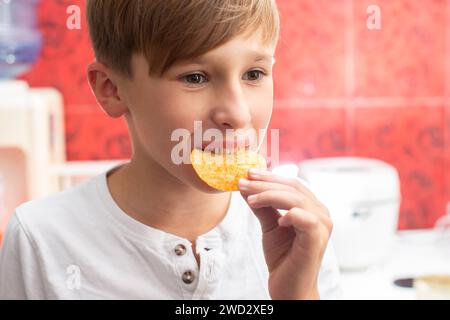 Junge isst Chips aus der Nähe. Kartoffelchips-Kind. Stockfoto