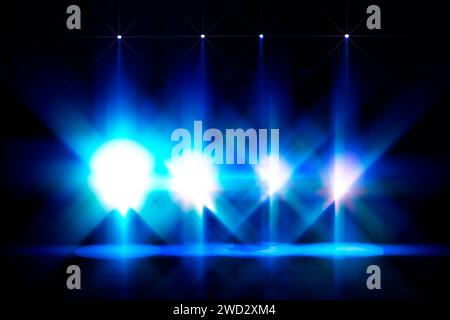 Blaue Szene, beleuchtet durch helle Spotlights. Weiße Lichter einer leeren Bühne. Stockfoto