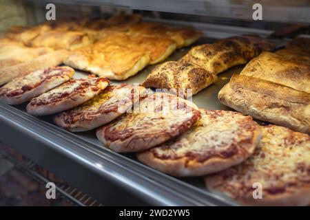 Frisch gebackene Focaccia al formaggio di Recco in einem Regal in einer traditionellen Pizzeria. Focaccia-Brot mit Käse. Käse-Focaccia mit Tomatenpaste. Stre Stockfoto