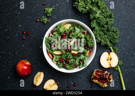 Hokkaido-Apfel- und Quinoasalat mit Grünkohl, Granatapfel, Frühlingszwiebeln und gerösteten Sonnenblumenkernen. Gesundes hausgemachtes Essen. Veganes Essen Stockfoto