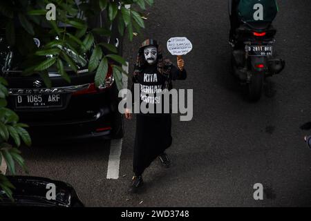 Bandung, West-Java, Indonesien. Januar 2024. Ein indonesischer Mimienkünstler, Wanggi Hoed, führt eine Aktion durch, bei der er 2 km vom Gedung Indonesia Menggugat in Richtung Gedung Sate, Bandung, zurückgeht. Die Aktion zum Gedenken an die siebzehnte Kamisan-Aktion wurde auch zum Symbol des Niedergangs der Demokratie in Indonesien. Die Kamisan-Aktion fand erstmals am 18. Januar 2007 in Jakarta statt, um Gerechtigkeit für Opfer von Menschenrechtsverletzungen zu fordern, und fand in verschiedenen Städten Indonesiens statt, darunter Bandung. (Kreditbild: © Dimas Rachmatsyah/ZUMA Press Wire) NUR REDAKTIONELLE VERWENDUNG! N Stockfoto