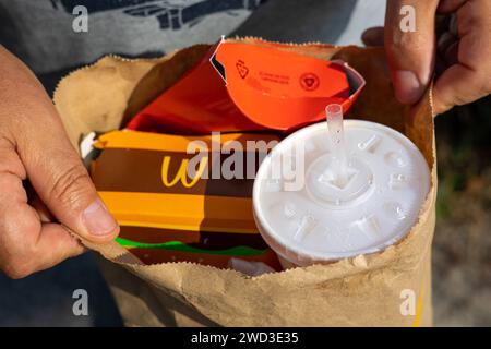 Gebrauchte Einwegpackungen aus Papier McDonalds in männlichen Händen. Fastfood-Müll-Vermächtnis. Entworfener Natron-Becher aus Papier. Stapel verlassener Müllverpackungen von Pommes Frites und Hamburger. Kiew, Ukraine, 08. Juli 2023 Copyright: XDmytroxNikolaienkox Stockfoto