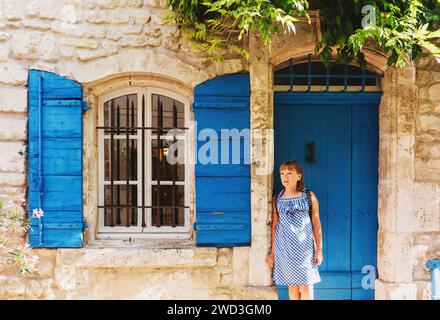 Hübsches kleines Touristenmädchen auf den Straßen der Provence, trägt blaues Gingham-Kleid, Sonnenbrille und Rucksack. Das Kinderreisekonzept. Bild aufgenommen Stockfoto