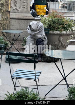 Ein Obdachloser wurde an einem kalten Wintertag vor dem i9n Bryant Park in Midtown Manhattan in eine Decke gerappt. Stockfoto