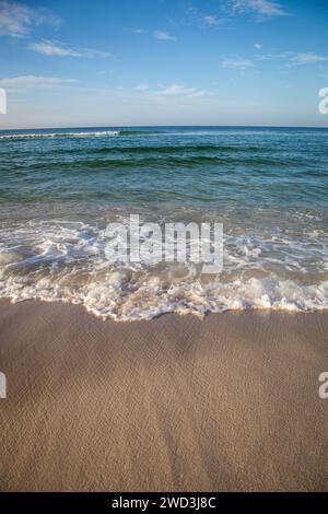 Kleine Wellen brechen an einer Sandküste in Panama City Beach, Florida Stockfoto