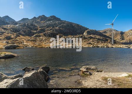 Windenergieanlage auf einem kleinen Bergsee auf der Spitze des Gotthardpasses, Kanton Tessin, Schweiz Stockfoto