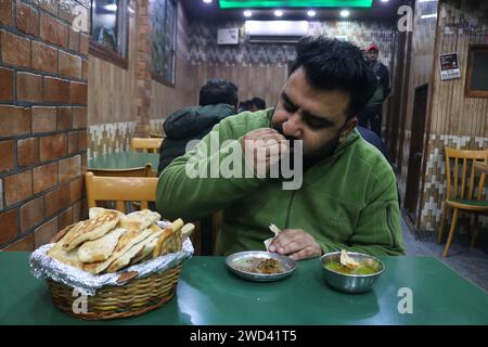 18. Januar 2024, Srinagar Kashmir, Indien: Ein Koch serviert Harissa an einem kalten Morgen in Srinagar. Harissa ist ein einzigartiges uraltes Hammelrezept, das während der Winter in Kaschmir zubereitet wird. Es ist meistens in den Morgenstunden aus Hammelfleisch, besonders von Schafen, erhältlich. Das Hammelfleisch wird zuerst bei milder Temperatur gekocht und alle Knochen werden extrahiert, um es entbeint zu machen. Das Hammelfleisch wird dann mit Reismehl, Wasser und verschiedenen Gewürzen gemischt und ständig umgerührt, bis es quaschig wird. Die Leute mögen dieses Gericht meistens mit gebackenem Brot. Am 18. Januar 2024 In Srinagar Kaschmir, Indien. (Foto Von Firdous Naz Stockfoto