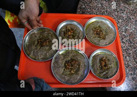 18. Januar 2024, Srinagar Kashmir, Indien: An einem kalten Morgen in Srinagar werden Platten mit Harissa für Kunden bereitgehalten. Harissa ist ein einzigartiges uraltes Hammelrezept, das während der Winter in Kaschmir zubereitet wird. Es ist meistens in den Morgenstunden aus Hammelfleisch, besonders von Schafen, erhältlich. Das Hammelfleisch wird zuerst bei milder Temperatur gekocht und alle Knochen werden extrahiert, um es entbeint zu machen. Das Hammelfleisch wird dann mit Reismehl, Wasser und verschiedenen Gewürzen gemischt und ständig umgerührt, bis es quaschig wird. Die Leute mögen dieses Gericht meistens mit gebackenem Brot. Am 18. Januar 2024 In Srinagar Kaschmir, Indien. ( Stockfoto