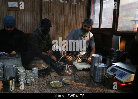 18. Januar 2024, Srinagar Kashmir, Indien: Ein Koch serviert Harissa an einem kalten Morgen in Srinagar. Harissa ist ein einzigartiges uraltes Hammelrezept, das während der Winter in Kaschmir zubereitet wird. Es ist meistens in den Morgenstunden aus Hammelfleisch, besonders von Schafen, erhältlich. Das Hammelfleisch wird zuerst bei milder Temperatur gekocht und alle Knochen werden extrahiert, um es entbeint zu machen. Das Hammelfleisch wird dann mit Reismehl, Wasser und verschiedenen Gewürzen gemischt und ständig umgerührt, bis es quaschig wird. Die Leute mögen dieses Gericht meistens mit gebackenem Brot. Am 18. Januar 2024 In Srinagar Kaschmir, Indien. (Foto Von Firdous Naz Stockfoto