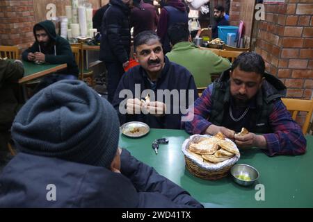 18. Januar 2024, Srinagar Kashmir, Indien: An einem kalten Morgen in Srinagar essen die Kunden Harissa (traditionelle Küche aus Kaschmir). Harissa ist ein einzigartiges uraltes Hammelrezept, das während der Winter in Kaschmir zubereitet wird. Es ist meistens in den Morgenstunden aus Hammelfleisch, besonders von Schafen, erhältlich. Das Hammelfleisch wird zuerst bei milder Temperatur gekocht und alle Knochen werden extrahiert, um es entbeint zu machen. Das Hammelfleisch wird dann mit Reismehl, Wasser und verschiedenen Gewürzen gemischt und ständig umgerührt, bis es quaschig wird. Die Leute mögen dieses Gericht meistens mit gebackenem Brot. Am 18. Januar 2024 In Srinagar Kaschmir, Indien. (Foto Stockfoto