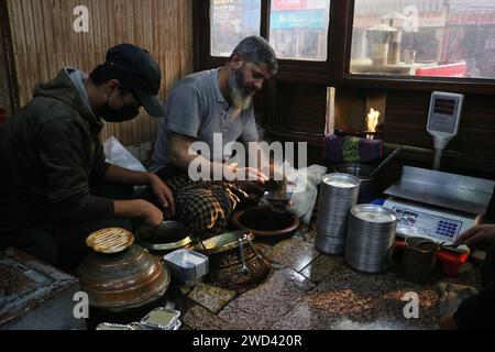 Srinagar Kaschmir, Indien. Januar 2024. Ein Koch serviert Harissa an einem kalten Morgen in Srinagar. Harissa ist ein einzigartiges uraltes Hammelrezept, das während der Winter in Kaschmir zubereitet wird. Es ist meistens in den Morgenstunden aus Hammelfleisch, besonders von Schafen, erhältlich. Das Hammelfleisch wird zuerst bei milder Temperatur gekocht und alle Knochen werden extrahiert, um es entbeint zu machen. Das Hammelfleisch wird dann mit Reismehl, Wasser und verschiedenen Gewürzen gemischt und ständig umgerührt, bis es quaschig wird. Die Leute mögen dieses Gericht meistens mit gebackenem Brot. Am 18. Januar 2024 In Srinagar Kaschmir, Indien. (Kreditbild: © Firdou Stockfoto