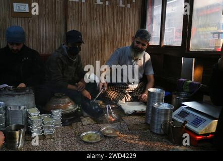 Srinagar Kaschmir, Indien. Januar 2024. Ein Koch serviert Harissa an einem kalten Morgen in Srinagar. Harissa ist ein einzigartiges uraltes Hammelrezept, das während der Winter in Kaschmir zubereitet wird. Es ist meistens in den Morgenstunden aus Hammelfleisch, besonders von Schafen, erhältlich. Das Hammelfleisch wird zuerst bei milder Temperatur gekocht und alle Knochen werden extrahiert, um es entbeint zu machen. Das Hammelfleisch wird dann mit Reismehl, Wasser und verschiedenen Gewürzen gemischt und ständig umgerührt, bis es quaschig wird. Die Leute mögen dieses Gericht meistens mit gebackenem Brot. Am 18. Januar 2024 In Srinagar Kaschmir, Indien. (Kreditbild: © Firdou Stockfoto