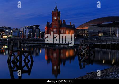 Das Pierhead Building, Senedd Building und Millennium Centre, Mermaid Quay, Cardiff Bay nach Sonnenuntergang mit Lichtern und Reflexionen. Vom Januar 2024 Stockfoto