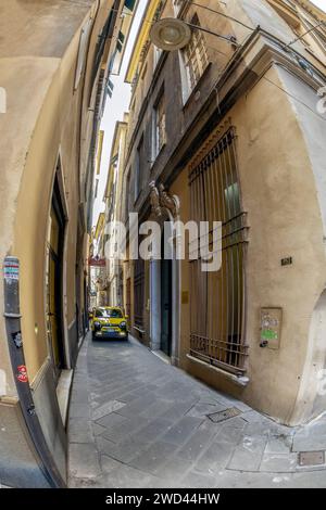 GENUA, ITALIEN - 20. MÄRZ 2021: Unglaublicher Autoverkehr auf den superengen Gassen des historischen Stadtzentrums. Typisch für die italienischen Städte. Stockfoto