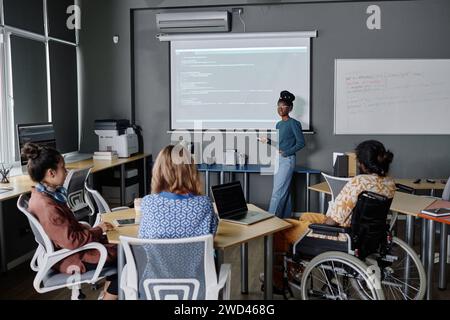 afroamerikanische Programmiererin hält eine Präsentation an Bord, multiethnische Kollegen hören ihr zu Stockfoto