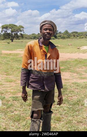 Glücklicher junger afrikanischer Mann aus dem Dorf mit einem großen, zahnlosen Lächeln auf der Straße an einem Sommertag Stockfoto