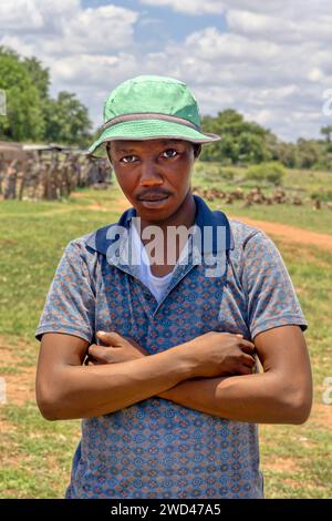 Junger afrikanischer Mann mit grünem Hut im Dorf an einem Sommertag Stockfoto