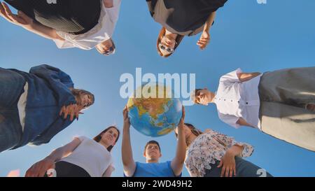 Das Konzept, die Welt zu schützen. Freunde, die einen geografischen Globus in den Händen halten. Stockfoto