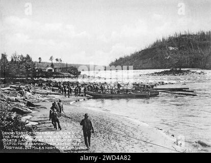 Ein Foto von 1901 von Pelzbooten, die auf dem Athabasca River landen, aufgenommen von C W Mathers auf einer Expedition in den hohen Norden Kanadas und veröffentlicht in seinem Buch „The Far North“. Mathers unterzeichnete dieses Foto: Grand Rapids, Athabasca River. Das Foto zeigt die Pelzboote von H.B.Co., die am Fuße des Schnellbootes landen, als Vorbereitung auf die Portage, 265 Meilen nördlich von Edmonton. Stockfoto