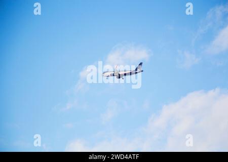 Weißes Passagierflugzeug, das am Himmel fliegt erstaunliche Wolken im Hintergrund - Reisen Sie mit dem Flugzeug. Stockfoto