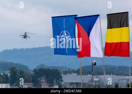 NATO, tschechische und deutsche Flagge mit einem russischen Mi24 Hind Hubschrauber im Hintergrund bei der NATO Days Airshow in Tschechien. Stockfoto