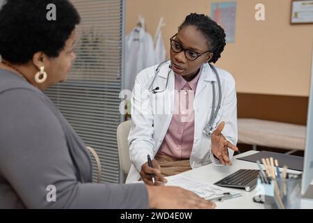 Ärztin spricht während des Besuchs mit dem Patienten Stockfoto