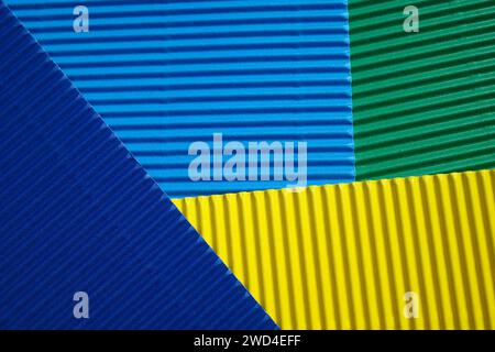 Horizontal und diagonal geriffelte Pappe mit den Farben Grün, Blau und Gelb. Als Hintergrund gedacht Stockfoto
