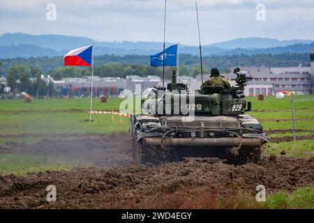 T72 Tank (M4 CZ Variantennummer 029) fährt während einer Demonstrationsübung auf einem schlammigen Feld vor NATO- und Tschechischen Flaggen. Stockfoto