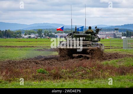 T72 Tank (M4 CZ Variantennummer 029) fährt während einer Demonstrationsübung auf einem schlammigen Feld vor NATO- und Tschechischen Flaggen. Stockfoto