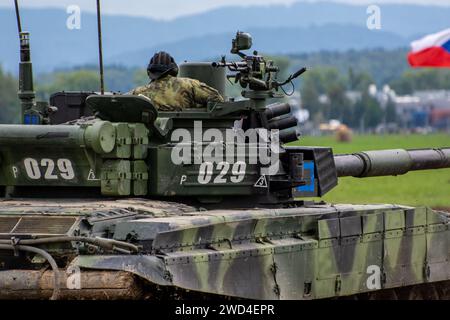 T72 Tank (M4 CZ Variantennummer 029) fährt während einer Demonstrationsübung auf einem schlammigen Feld vor NATO- und Tschechischen Flaggen. Stockfoto