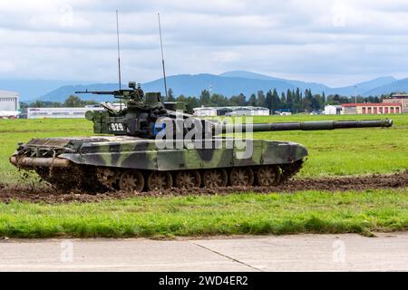 T72 Tank (M4 CZ Variantennummer 029) fährt während einer Demonstrationsübung auf einem schlammigen Feld vor NATO- und Tschechischen Flaggen. Stockfoto