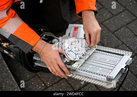 Ingenieur, der an der Instillation von Glasfaserkabeln in Anschlusskasten für unterirdische Entenarbeiten arbeitet, Großbritannien Stockfoto