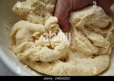 Mehl mit Wasser mischen. Zu einem Teig für die Zubereitung von Chebureks machen Stockfoto