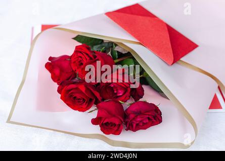Strauß aus roten Rosen mit einer Begleitkarte Stockfoto