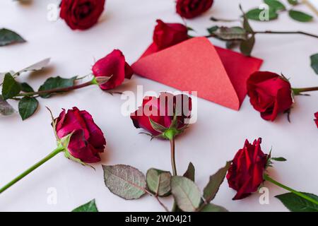 Rote Rosen, Karte und Schere vor einem wunderschönen Blumenstrauß Stockfoto