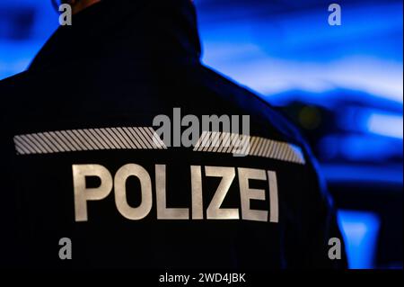 Dresden, Deutschland. Januar 2024. Ein Polizist steht neben einem Polizeiauto. Robert Michael/dpa/Alamy Live News Stockfoto