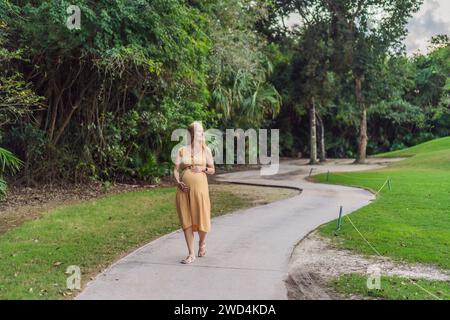 Ruhige Szene, in der eine schwangere Frau friedliche Momente im Park genießt, die Ruhe der Natur genießt und während ihrer Schwangerschaft Trost findet Stockfoto